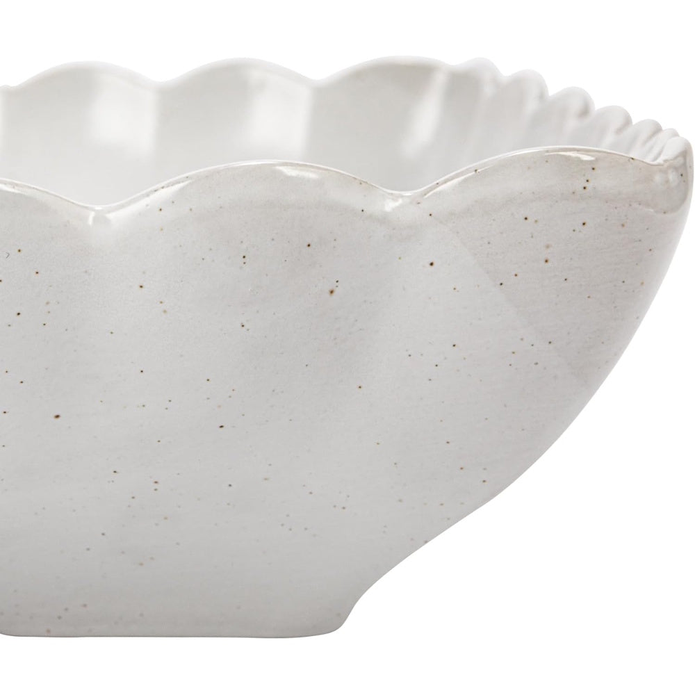White speckled stoneware bowl with a scalloped edge.