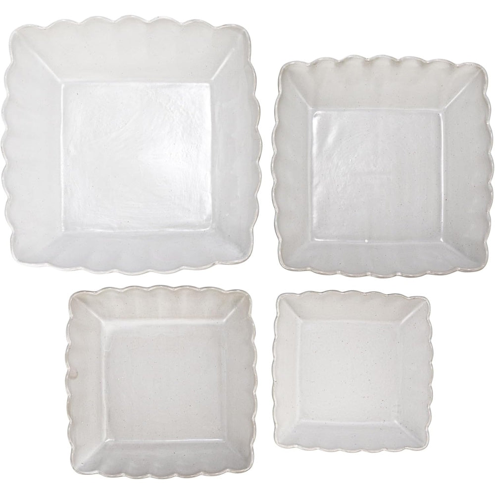 Top view of a set of four matte white square stoneware nesting bowls with scalloped edges.