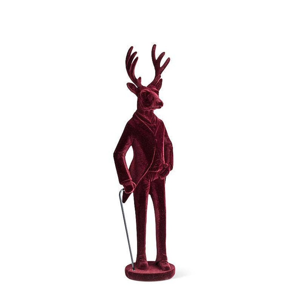 Deep red velvet stag figurine wearing a suit and holding a cane against a white background.