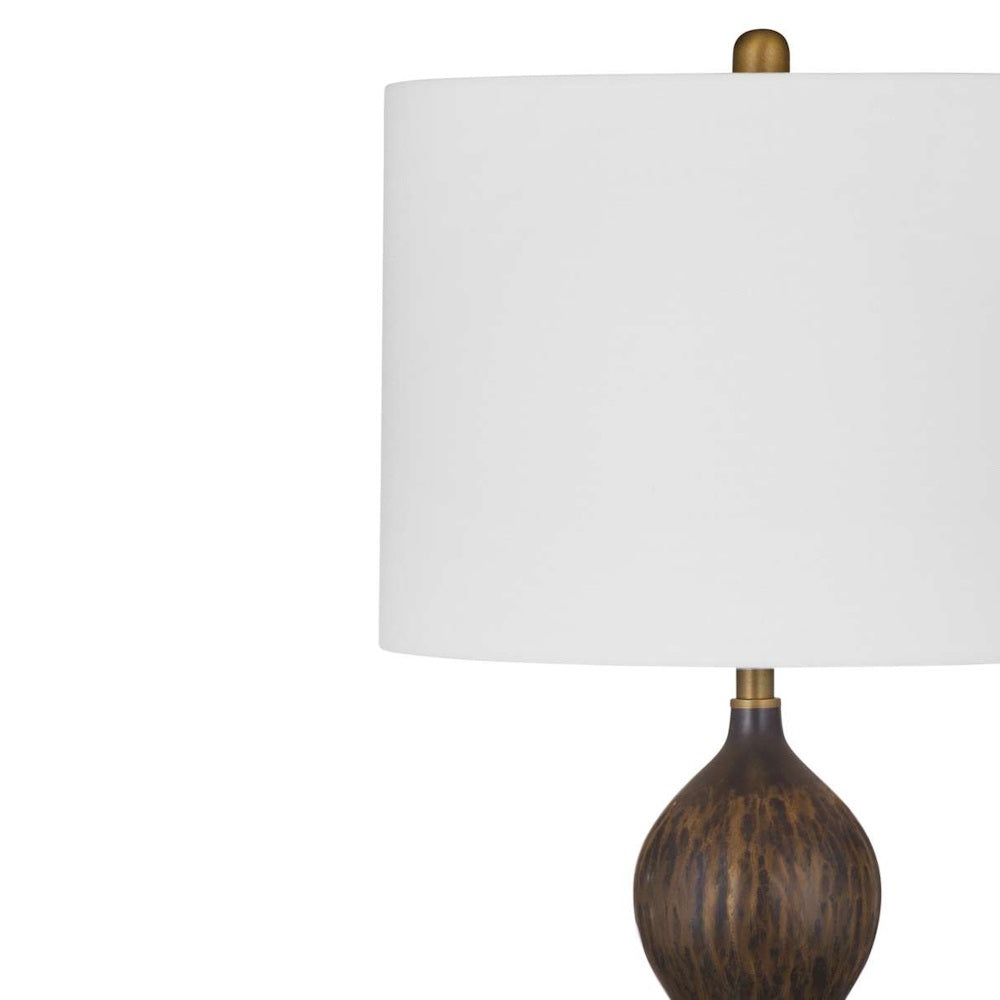 Mottled bronze double-gourd table lamp set on a wooden tabletop next to stacked decorative books.