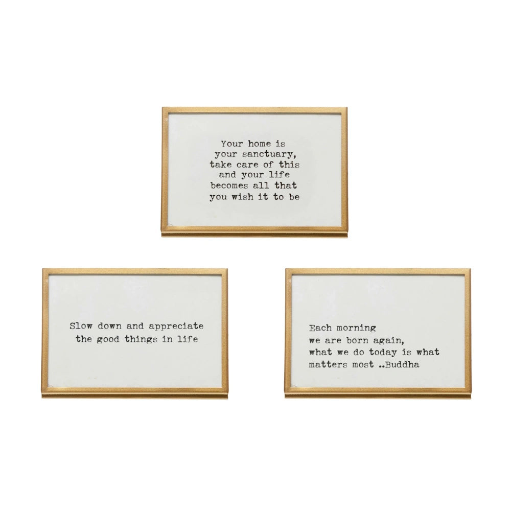 Three gold-framed inspirational signs with typewriter-style quotes about home, gratitude, and mindfulness on a white background.