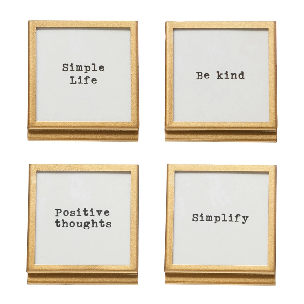 Four square gold metal frames with typewriter-style inspirational quotes including "Simple Life" and "Be Kind."