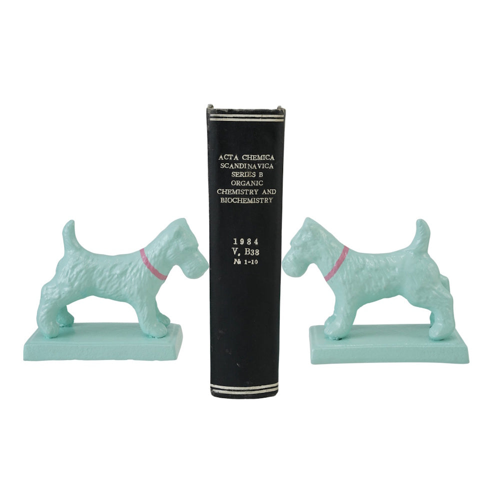 Pair of mint-green Scottish Terrier bookends with pink collars holding up a black vintage chemistry book.