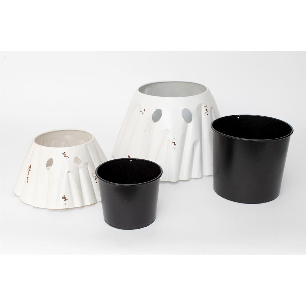 Two white metal ghost planter covers alongside two removable black inner pot liners.