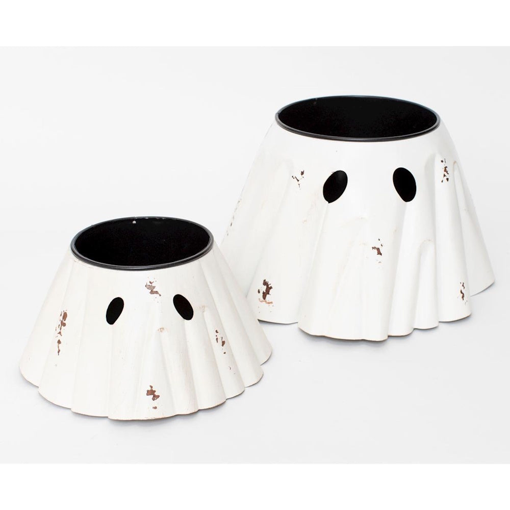Two white, ghost-shaped metal planters with black eyes on a white background.