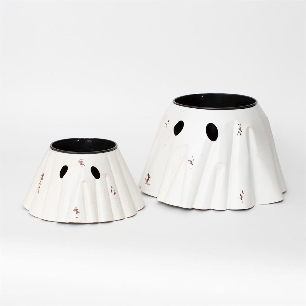 Pair of distressed white metal ghost-shaped planters in two sizes with black oval cut-out eyes.