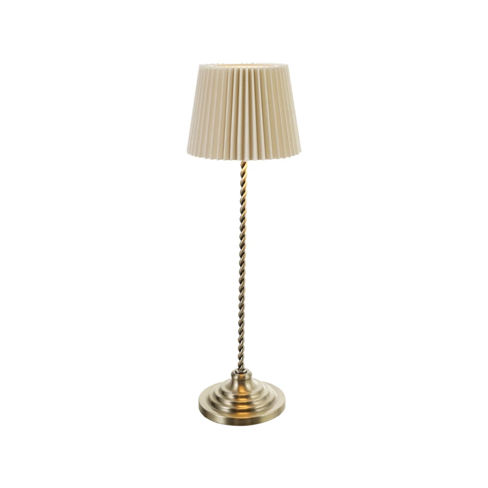 Front view of the lit rechargeable metal table lamp with a twisted stem and glowing pleated shade.