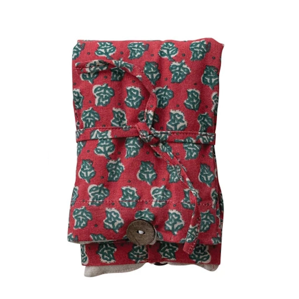 Red floral microwaveable hot and cold pack with green leaf block print, tied with a matching fabric ribbon.