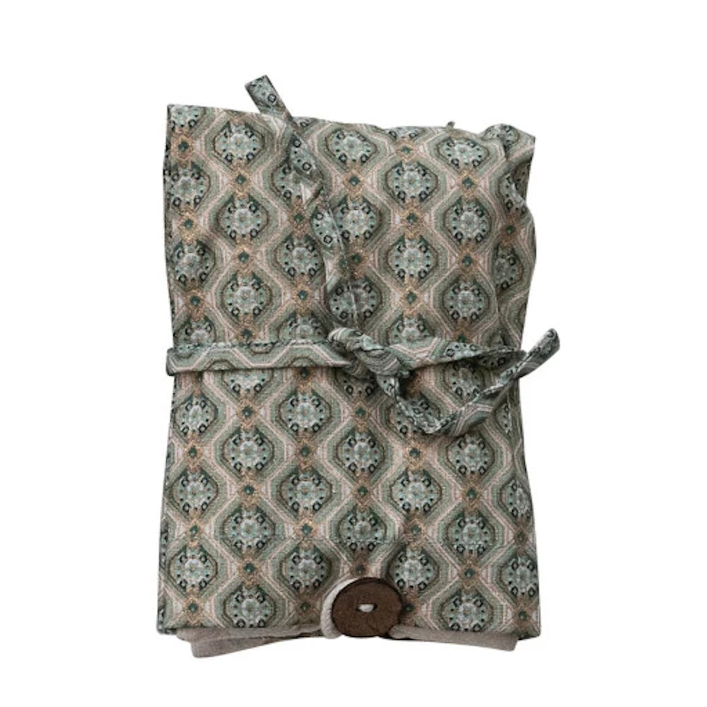Patterned green microwaveable hot cold pack with lavender and lentils, featuring a tie closure and button detail.