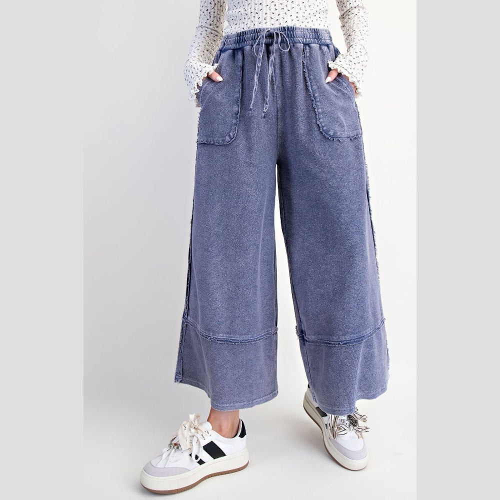 Midnight blue mineral washed palazzo pants with drawstring waist, raw hem, and front pockets for a relaxed boho look.