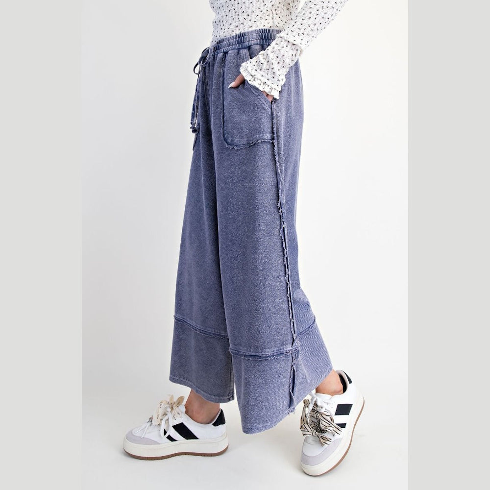Midnight blue mineral washed palazzo pants with raw edge seams, elastic drawstring waist, and pockets.