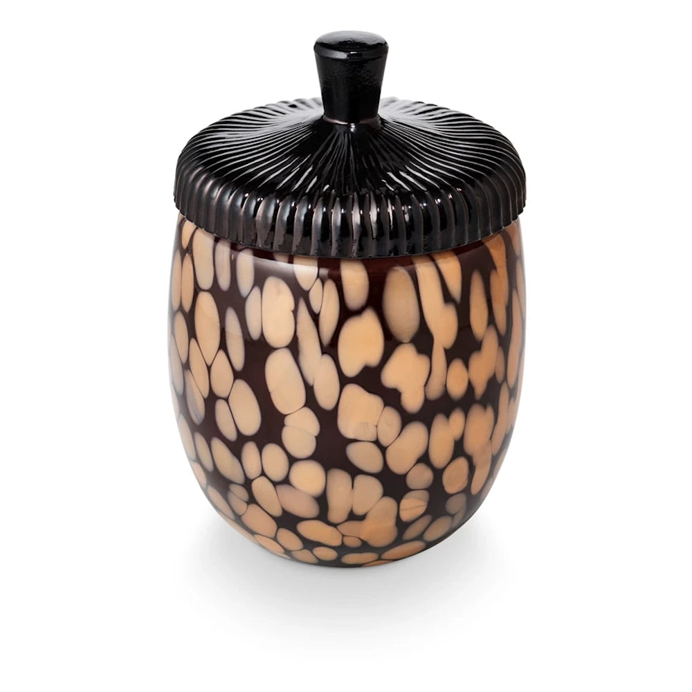 Acorn-shaped glass candle jar with a tortoiseshell pattern and a ridged black lid featuring a small handle.