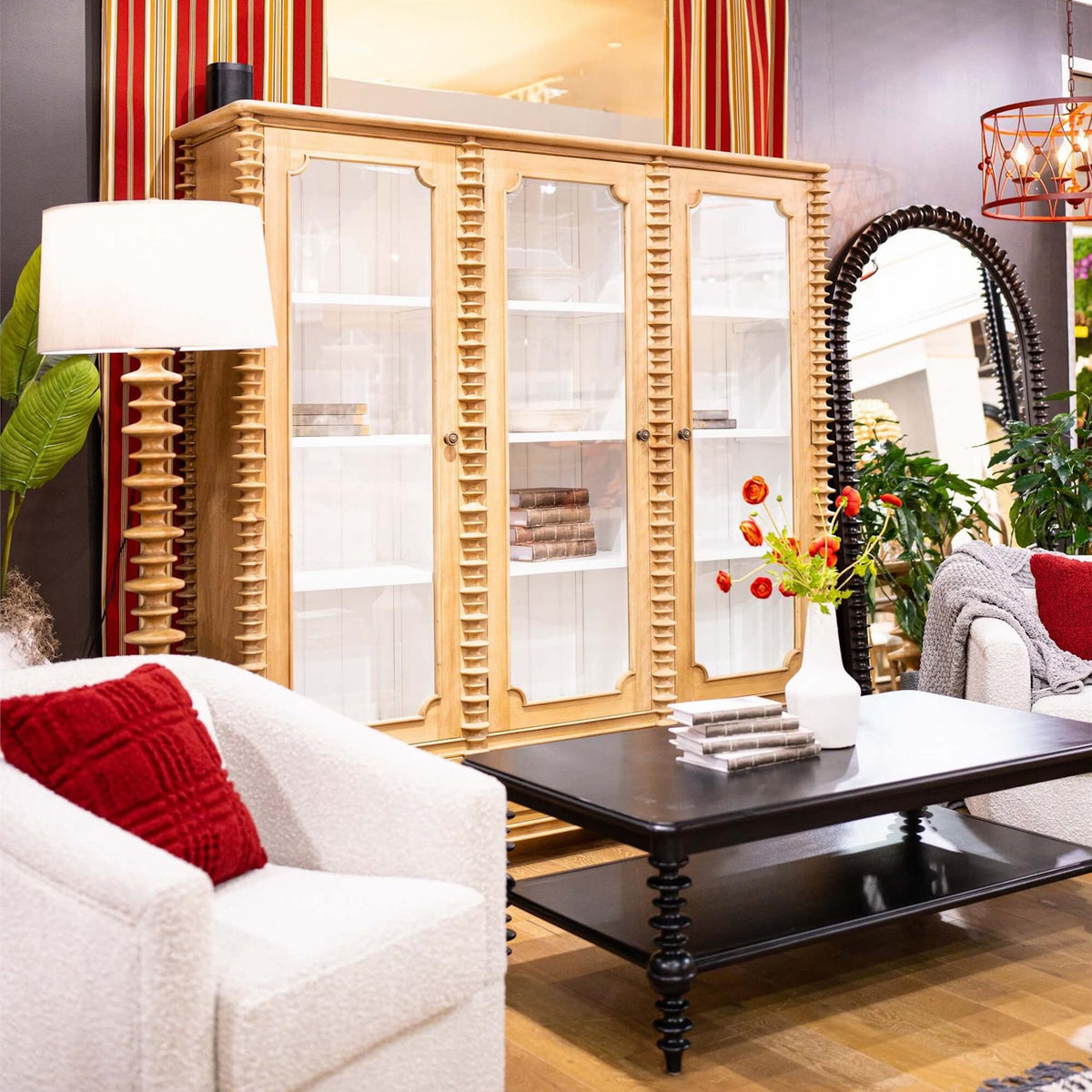 Black Milano coffee table in a living room setup with a wooden display cabinet and white armchairs.