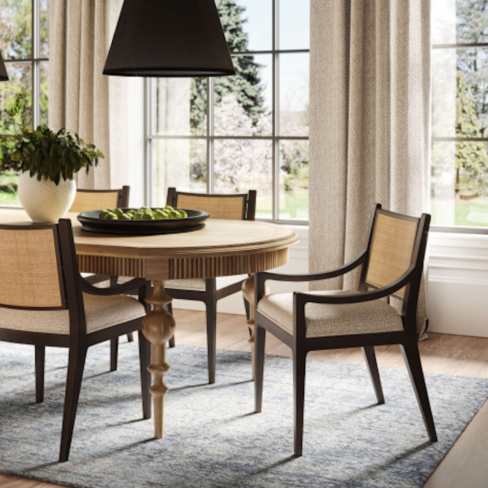 Milano dining chair with upholstered seat and rattan back at a wooden table.