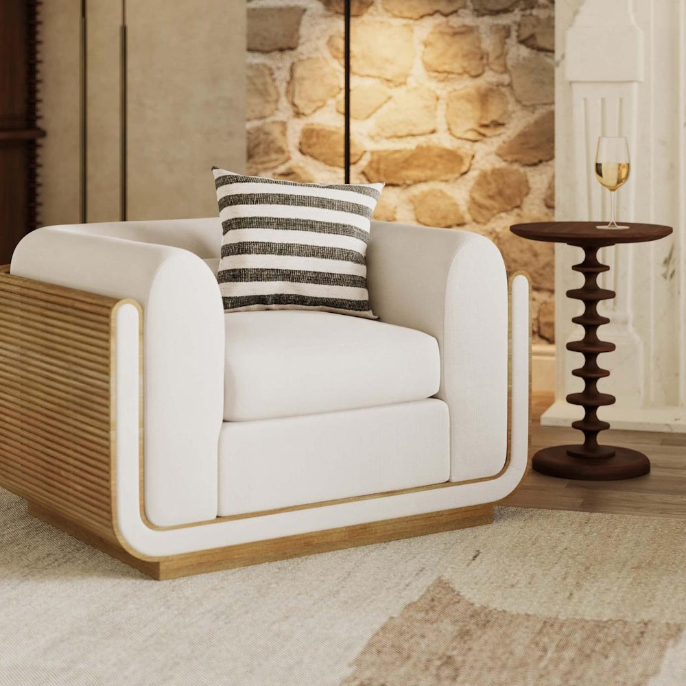 Modern armchair with striped pillow next to a Milano round wooden side table holding a wine glass.