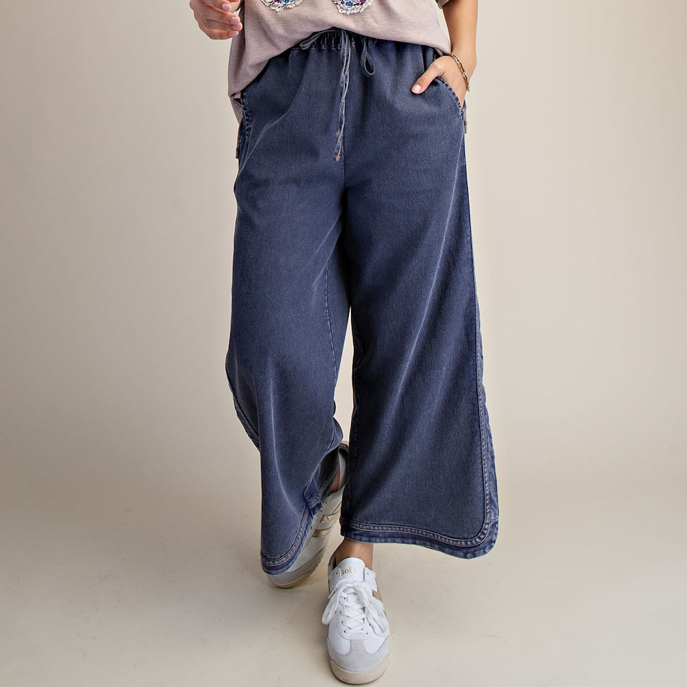 Dark mineral-wash wide-leg denim pants featuring a drawstring waistband and split hem detailing.