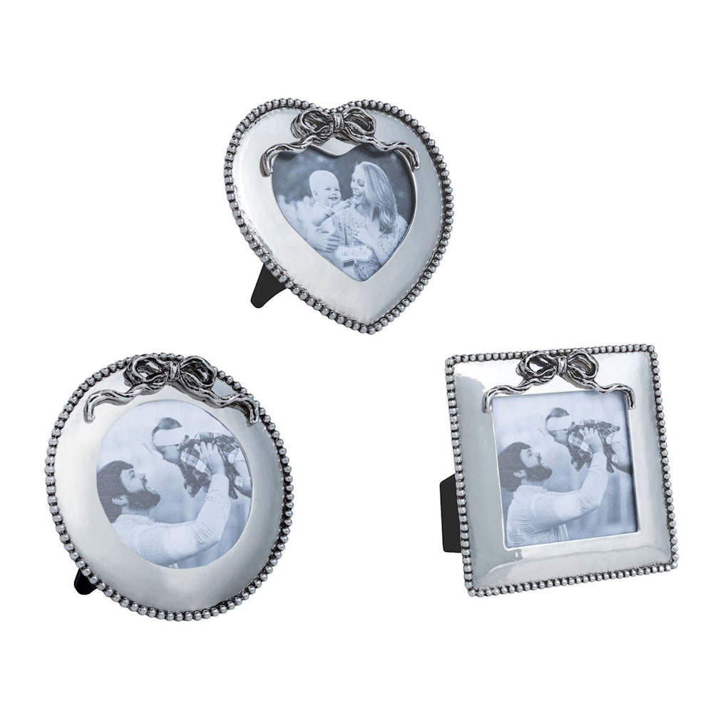 Three silver mini photo frames in heart, round, and square shapes with beaded edges and bow details on a white background.