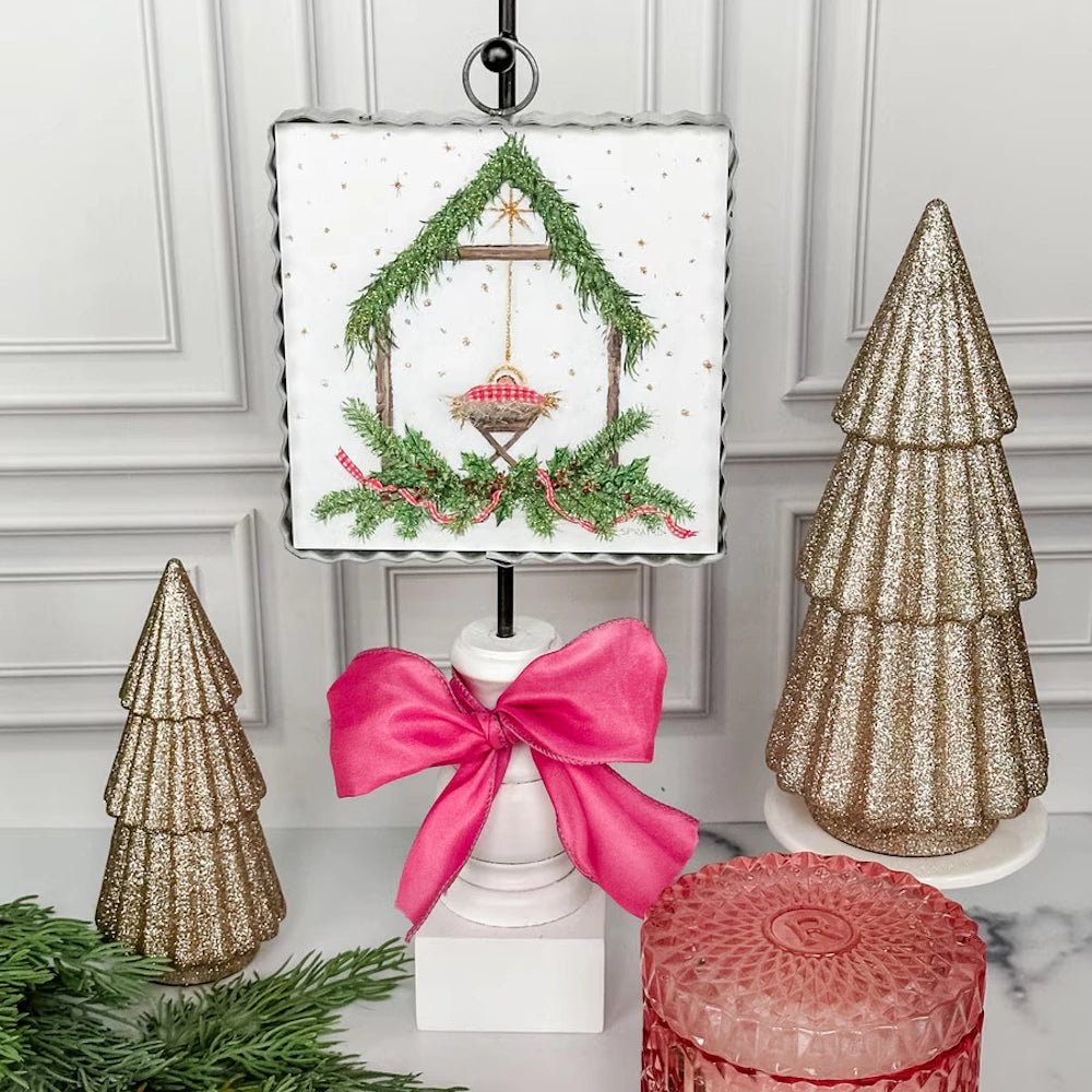 Front view of the white and green Gingham King art plaque displaying a nativity scene on a metal display stand.