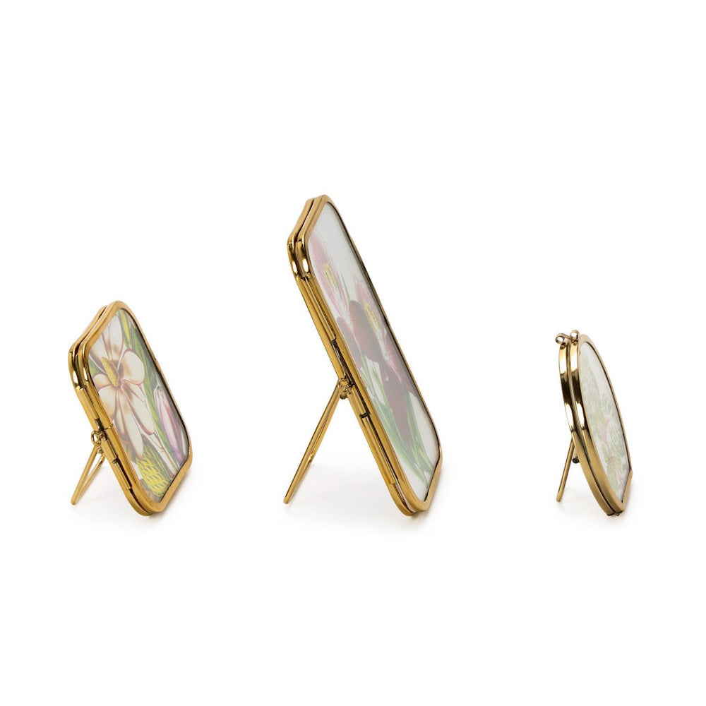 Set of three mini antique gold metal picture frames standing on a white background.