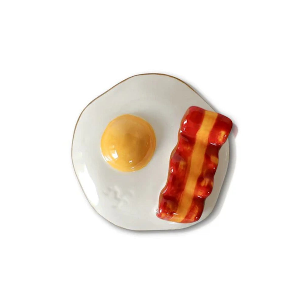 Ceramic fried egg and bacon strip trinket dish with a glossy finish on a white background.