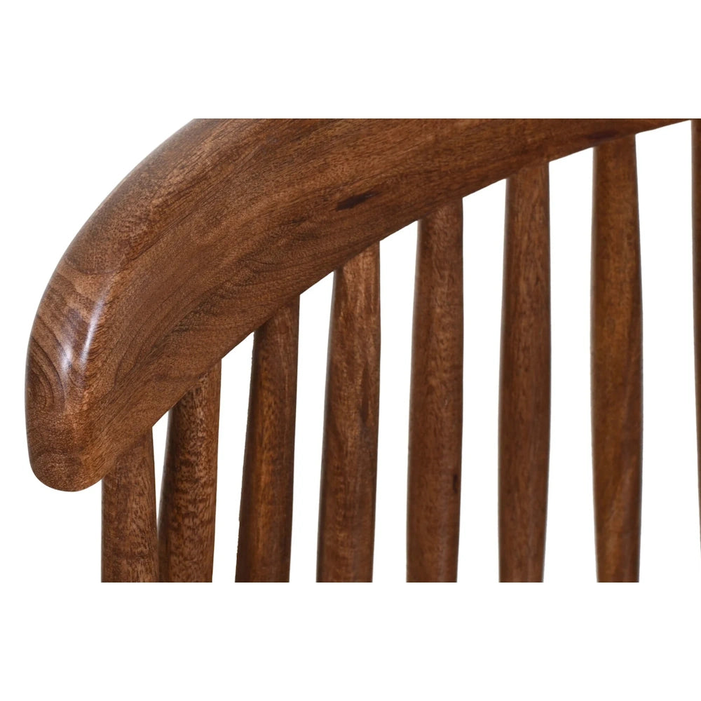 Close-up of a mid-century modern walnut chair with a curved wooden back and spindle detailing.