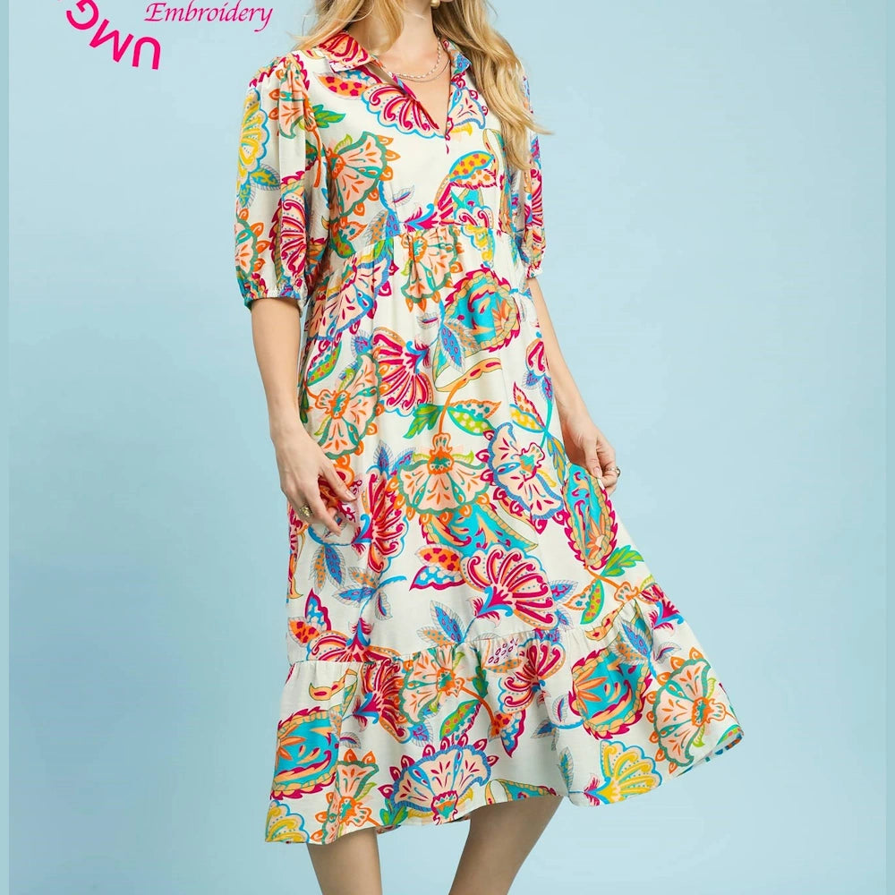 Cream maxi dress with a colorful mixed paisley print, featuring elbow-length puff sleeves and a tiered skirt.
