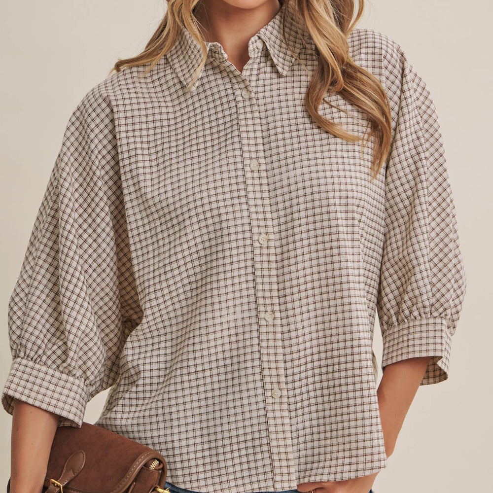 Front view of a woman wearing a mocha brown micro-grid plaid button-down shirt with three-quarter sleeves.