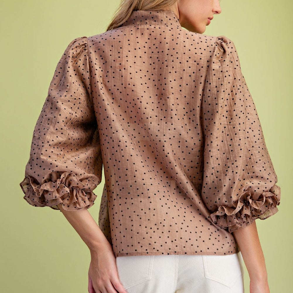 Back view of mocha polka dot woven blouse featuring high collar and ruffled puff sleeves.