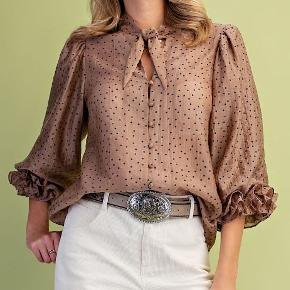 Front view of mocha polka dot woven blouse with neck tie, covered buttons, and ruffled cuffs.