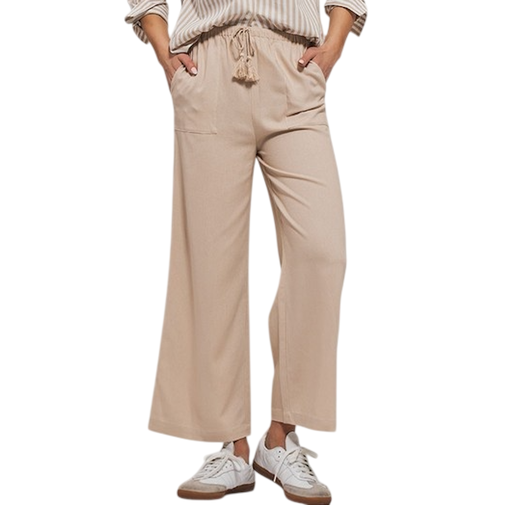 A person wears beige wide-leg pants with a tassel drawstring waist, paired with white sneakers.
