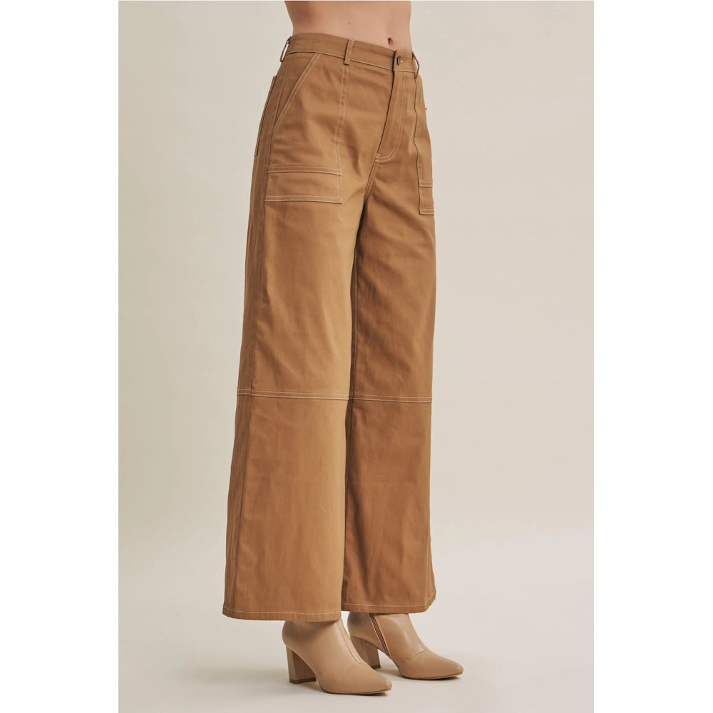 Side-angle view of camel wide-leg cotton twill pants with white contrast stitching and utility pockets.
