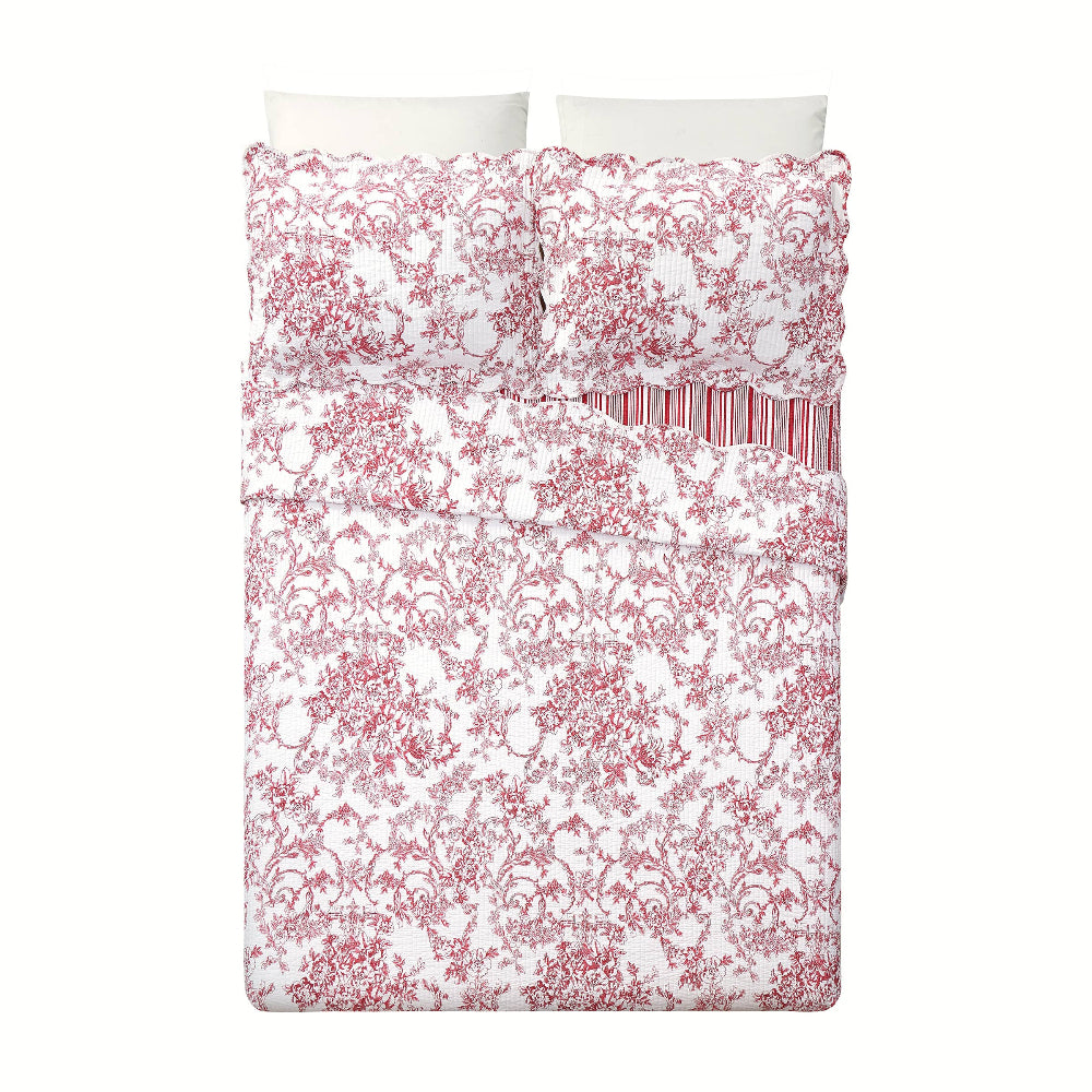 Modern Heirloom red garden toile quilt set with floral pattern, scalloped edges, and matching shams on a white bed.