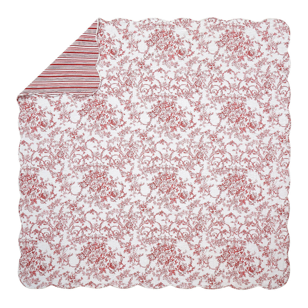Red garden toile quilt with scalloped edges and a red and white striped reverse side for traditional bedroom decor.
