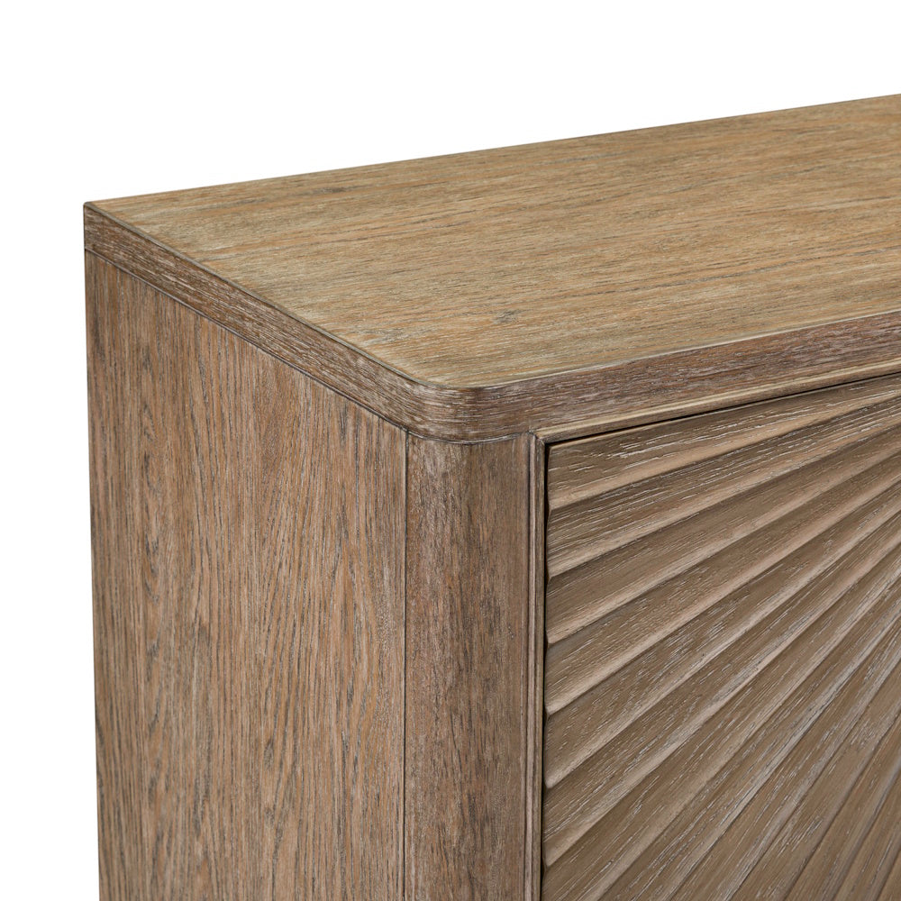 Close-up of the wooden accent cabinet showing the rounded top edge and detailed sunburst door panel.