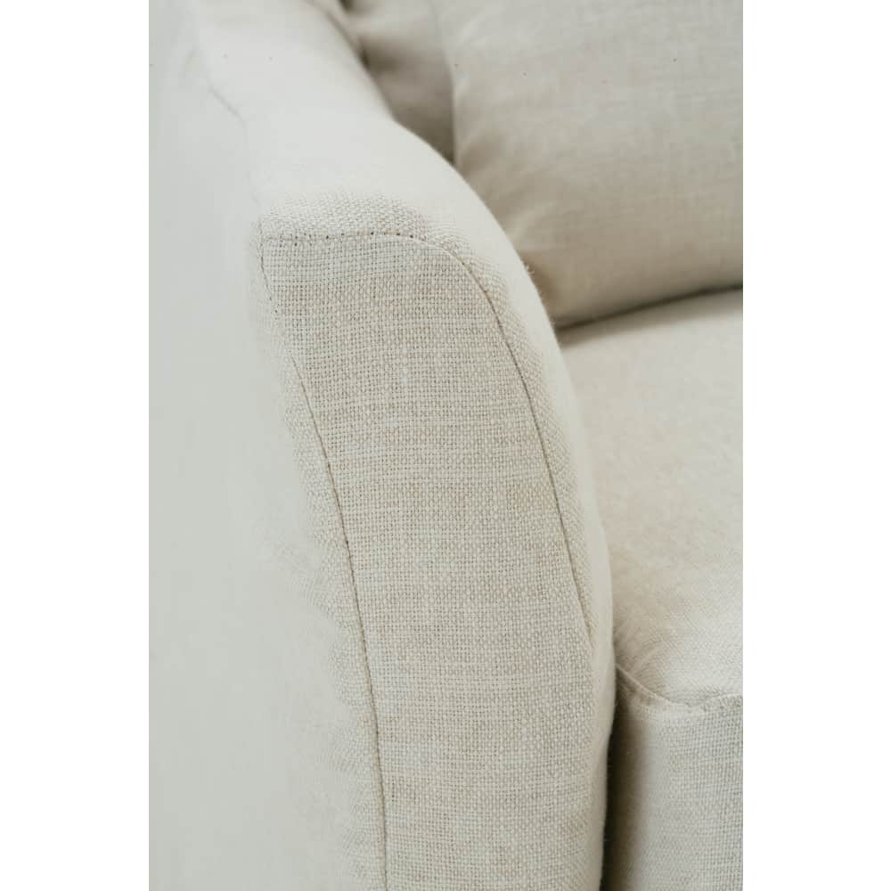 Close-up of a Moreau slipcovered sofa arm in a textured beige linen fabric showing detail stitching.