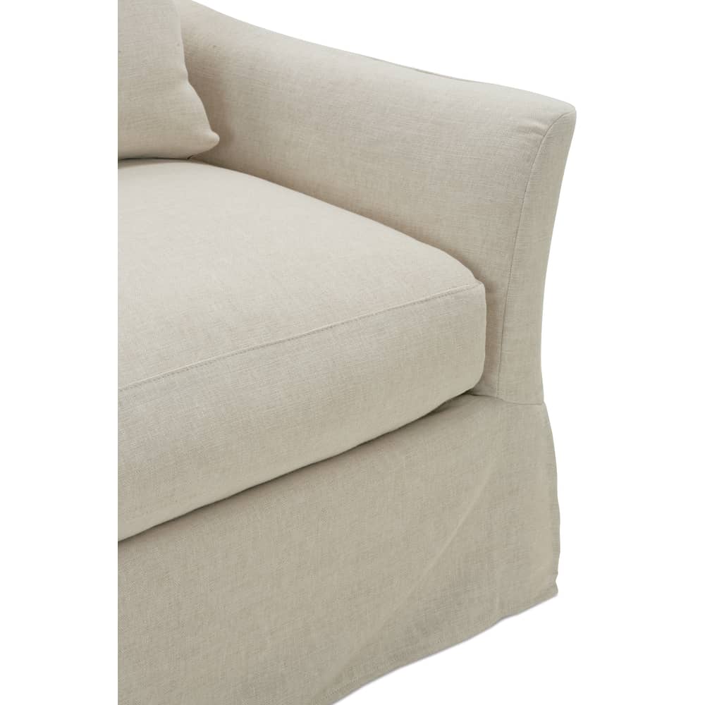 Detail view of a Moreau slipcovered sofa cushion and pleated base skirt in a beige linen fabric.