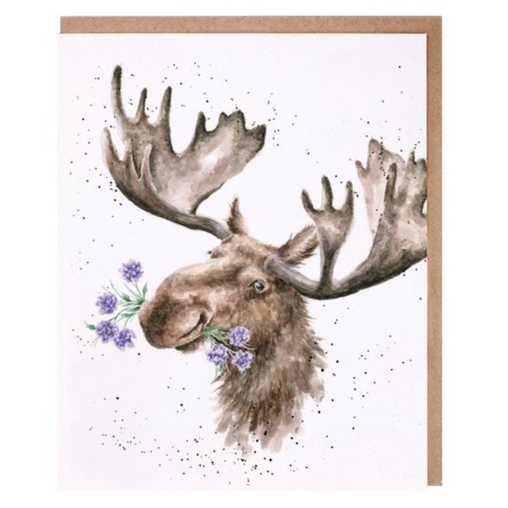 Watercolor illustration of a moose with purple flowers in its mouth on a white card with a kraft envelope.