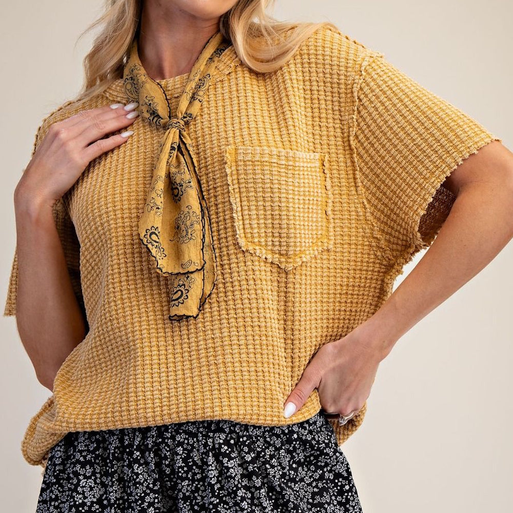 Mustard yellow waffle-knit short-sleeve top with a chest pocket and a matching paisley neck scarf.