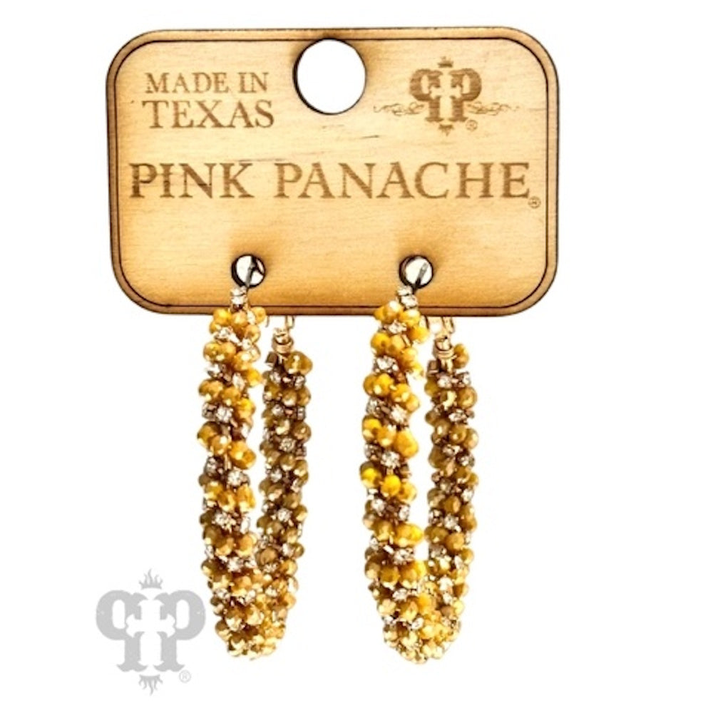 A pair of mustard yellow and rhinestone beaded hoop earrings on a wooden Pink Panache display card.