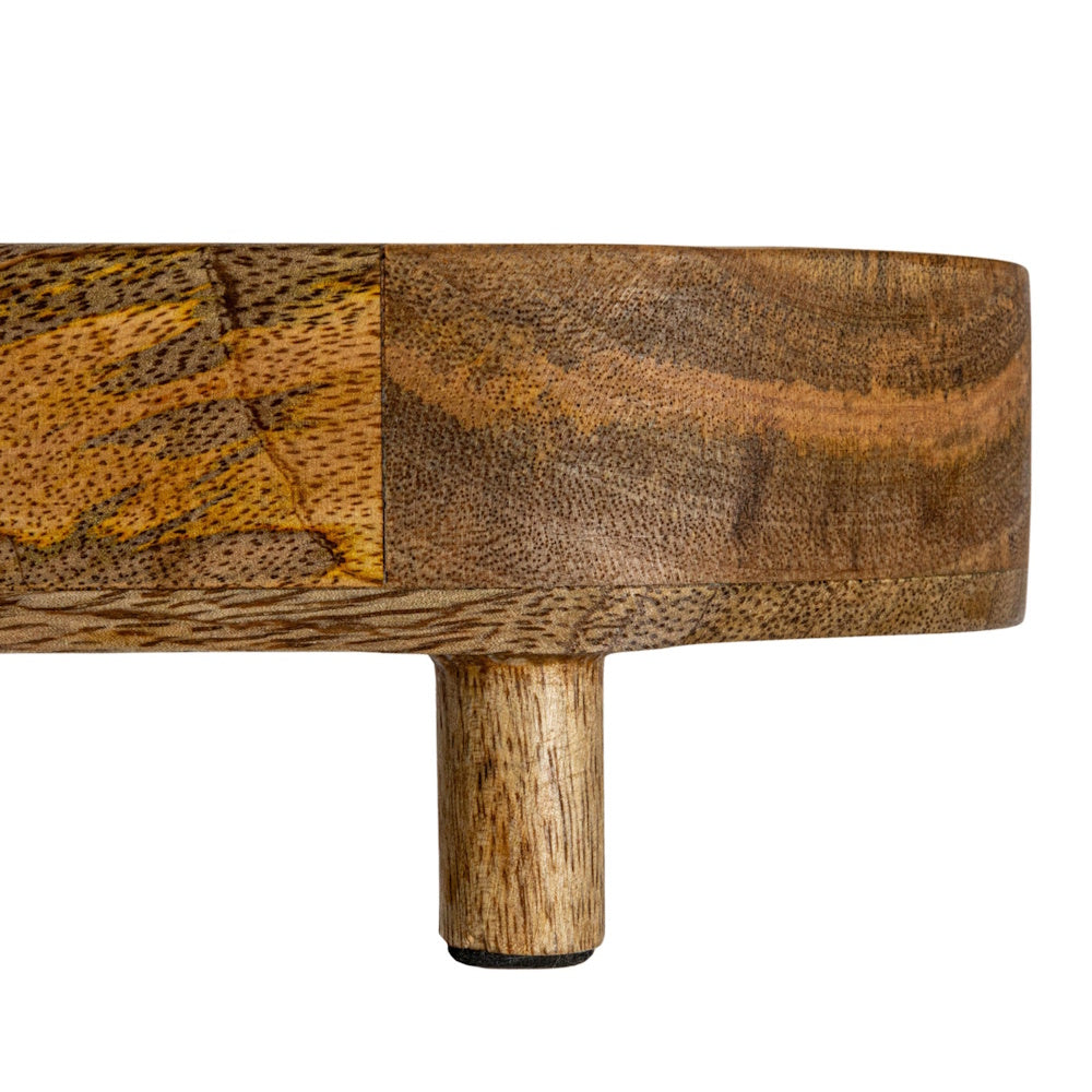 Close-up of a natural mango wood footed tray showcasing its textured grain pattern and small cylindrical leg.