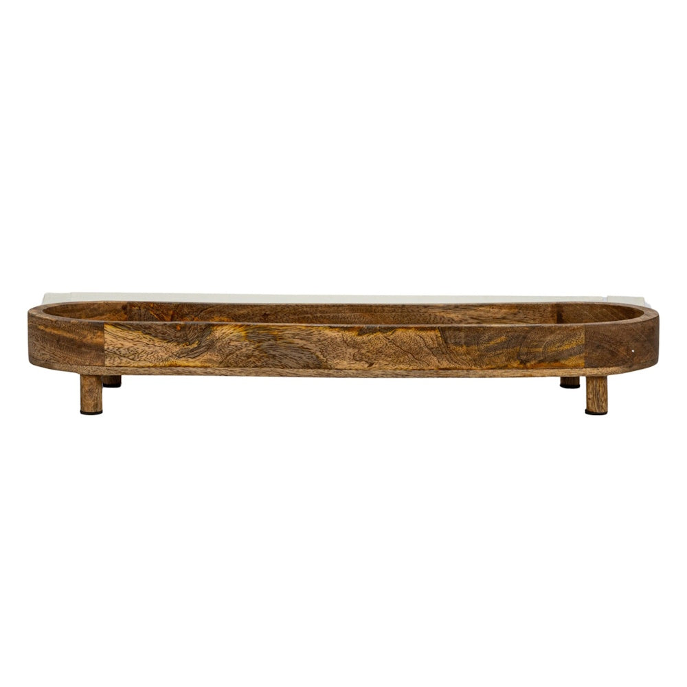 Side view of a long, oval-shaped natural mango wood footed tray showing its unique wood grain pattern.