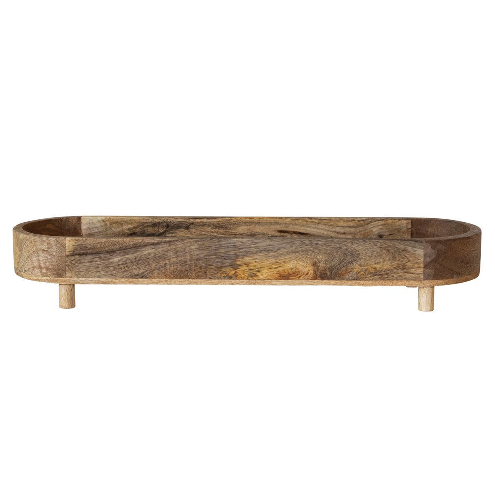 Natural mango wood footed tray with a long, rounded oval shape and distinct rustic grain patterns on a white background.