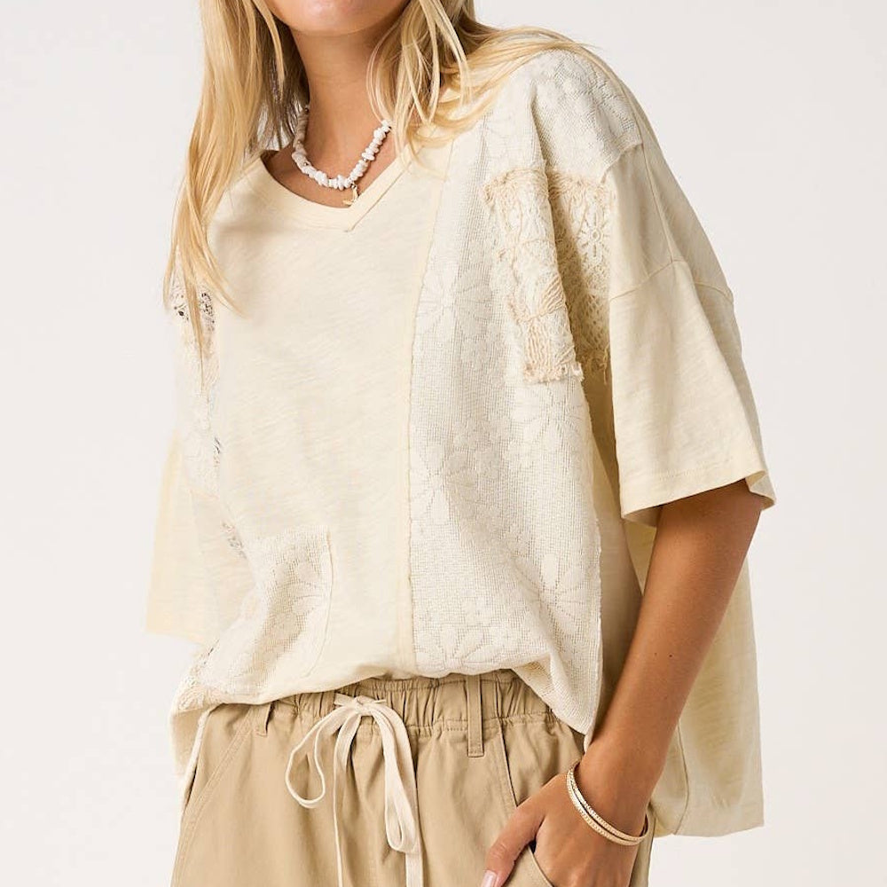 Natural patchwork lace V-neck short sleeve top in cream, paired with khaki drawstring pants and a shell necklace.