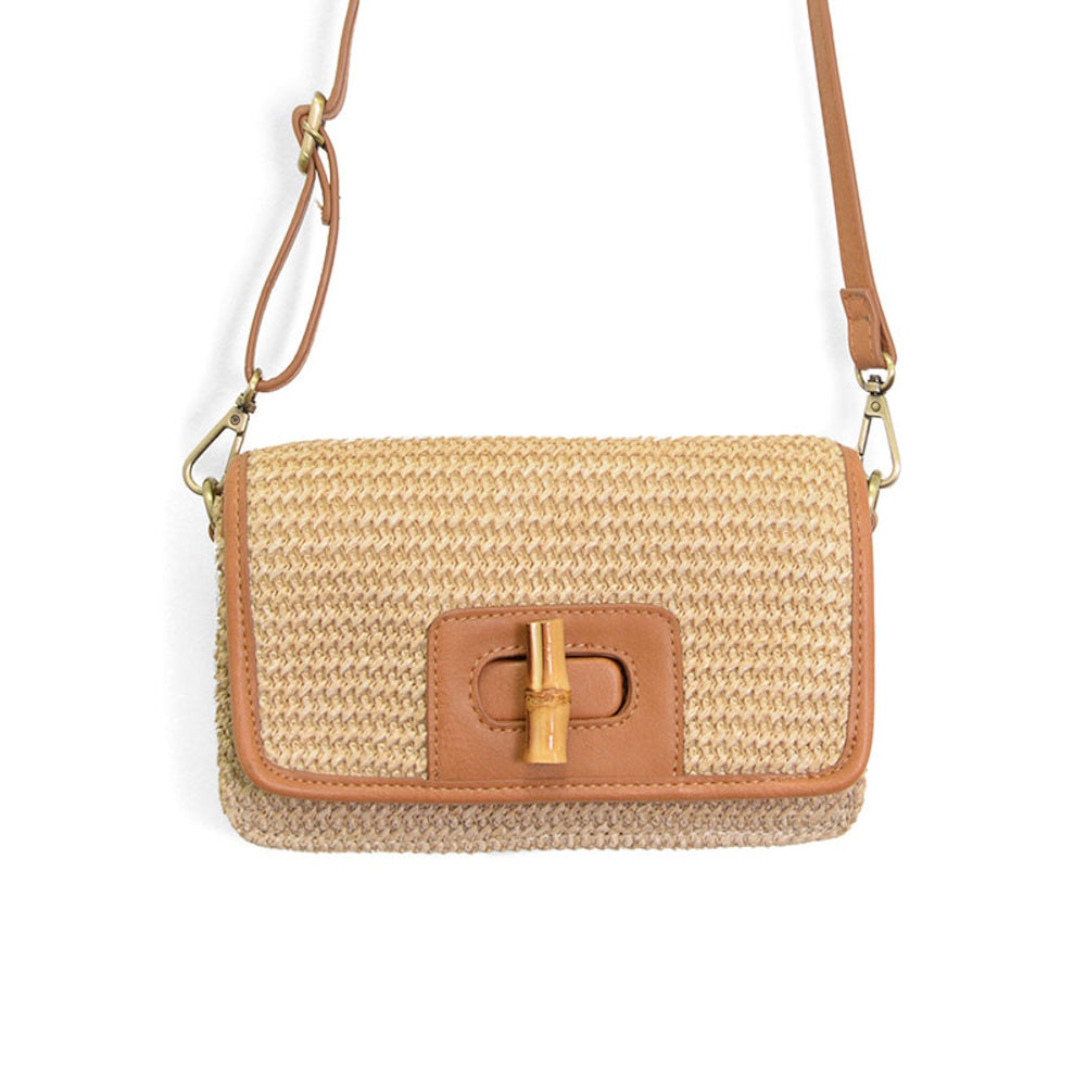 Natural straw crossbody bag with brown leather trim, a bamboo turnlock closure, and an adjustable shoulder strap.