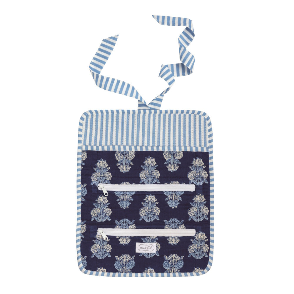 Open navy block-print quilted jewelry roll featuring two interior zipper pockets and a blue striped ribbon tie.