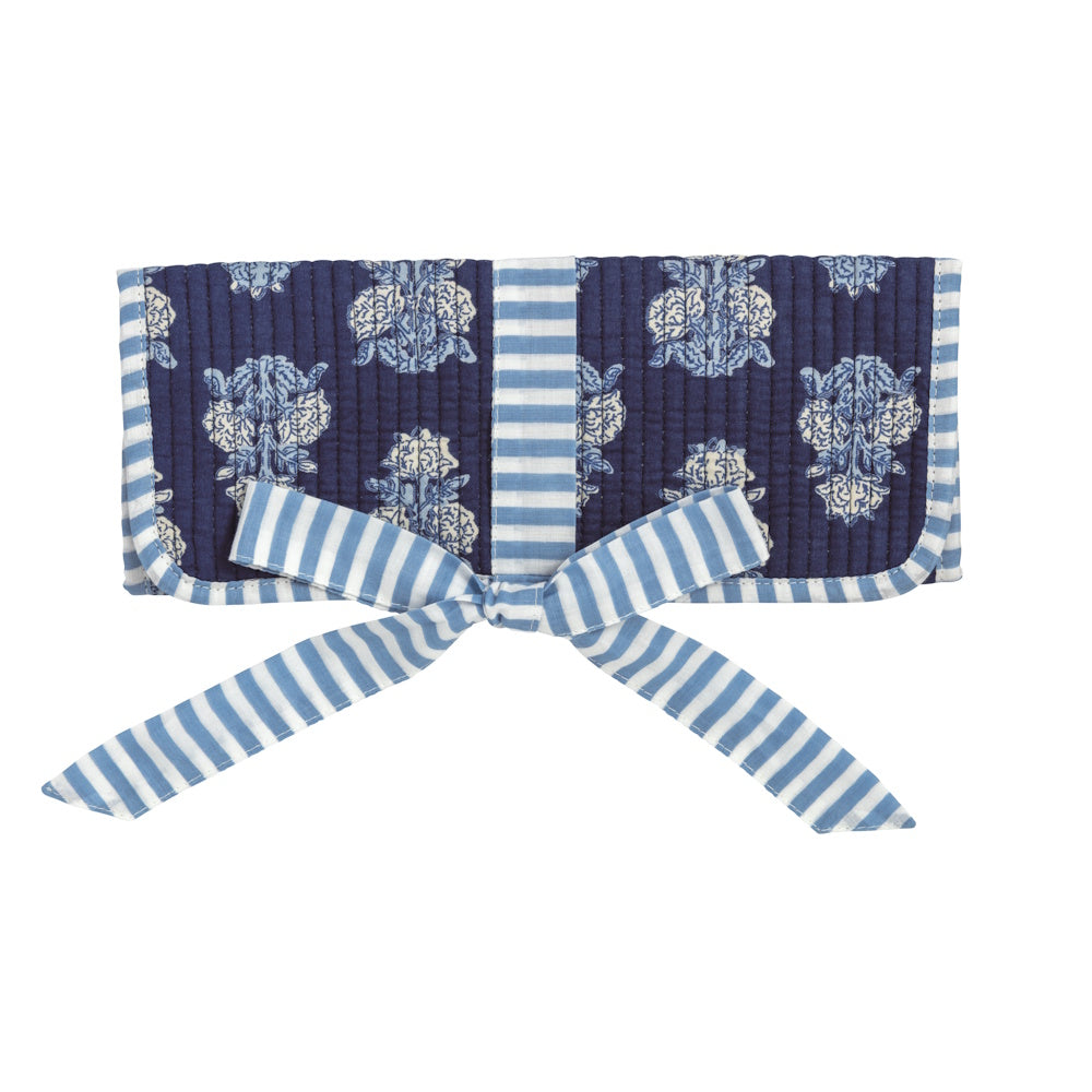 Navy blue and white block-print floral jewelry roll with light blue striped ribbon tie closure on a white background.