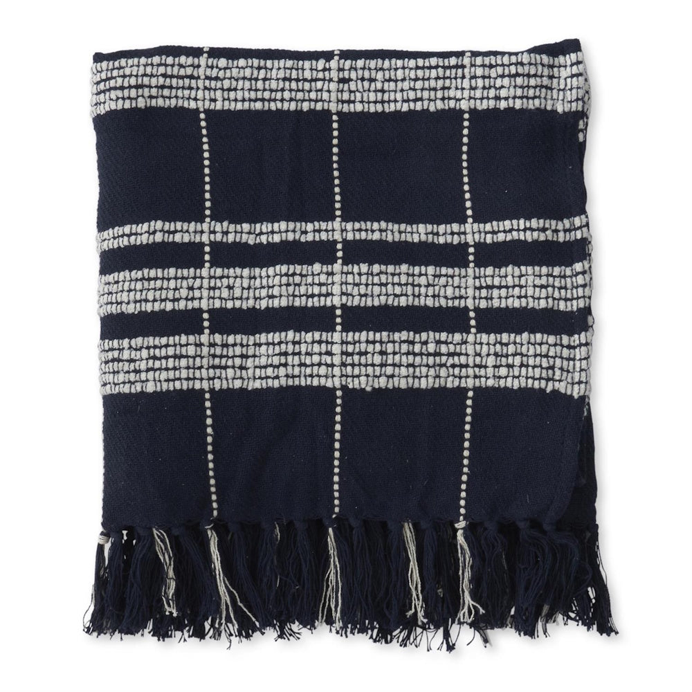 Folded navy blue woven throw blanket with cream textured grid lines and fringe accents.