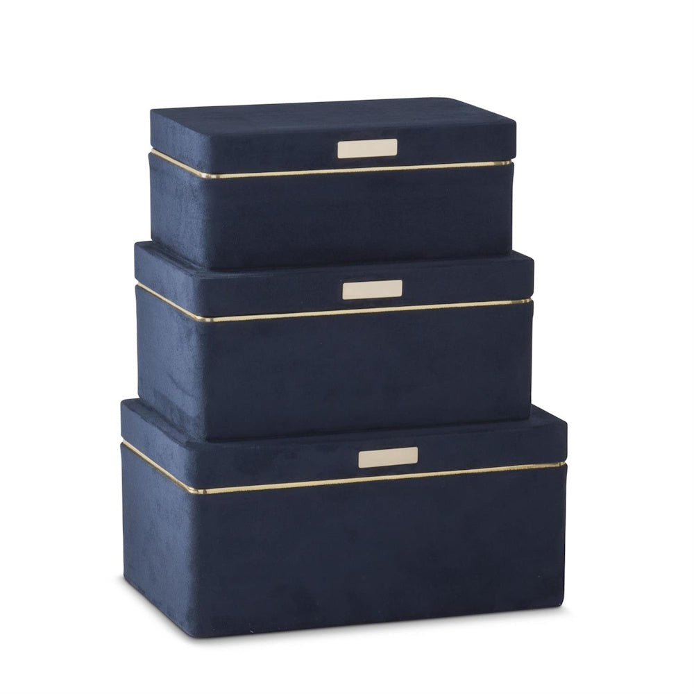 Three navy blue suede jewelry boxes with gold trim stacked from largest to smallest on a white background.