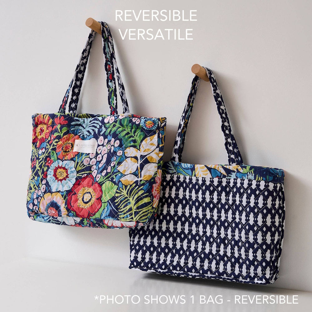 Reversible quilted tote bag with floral garden print on one side and blue geometric pattern on the other.
