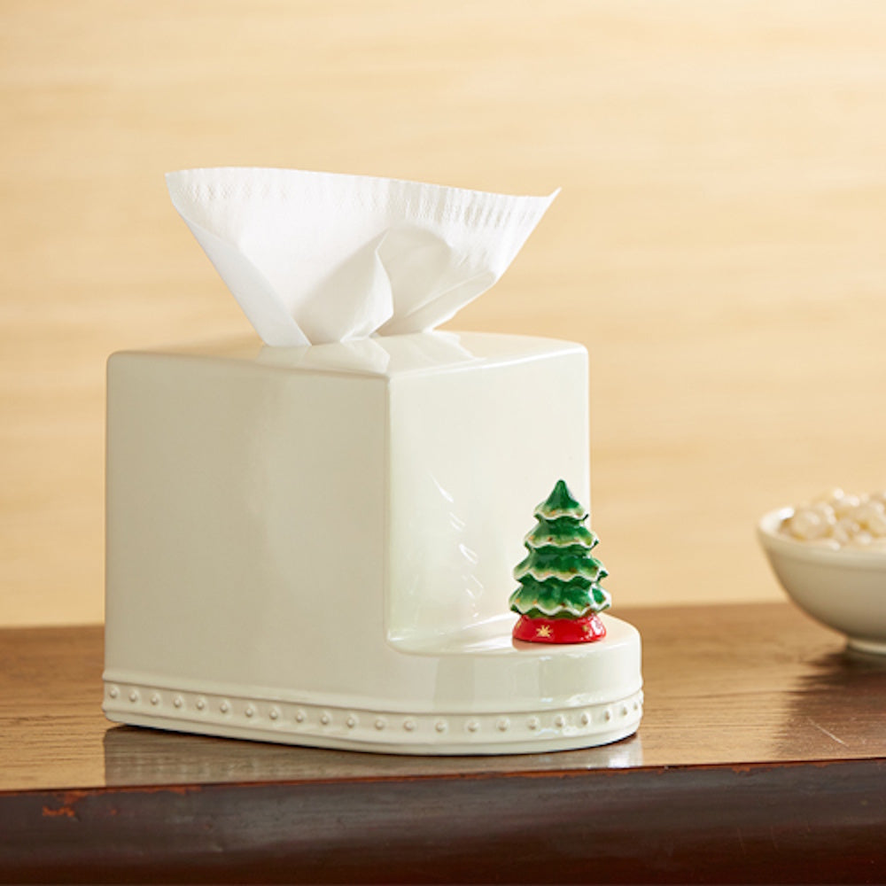 White ceramic tissue box cover with a small, green ceramic Christmas tree figurine attached to the front base.